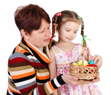 Little girl and her grandmother with basket full of easter eggs